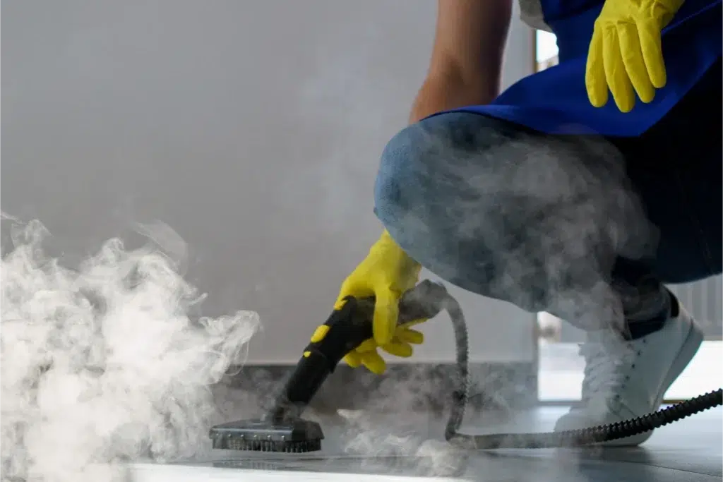 Person steam cleaning a floor