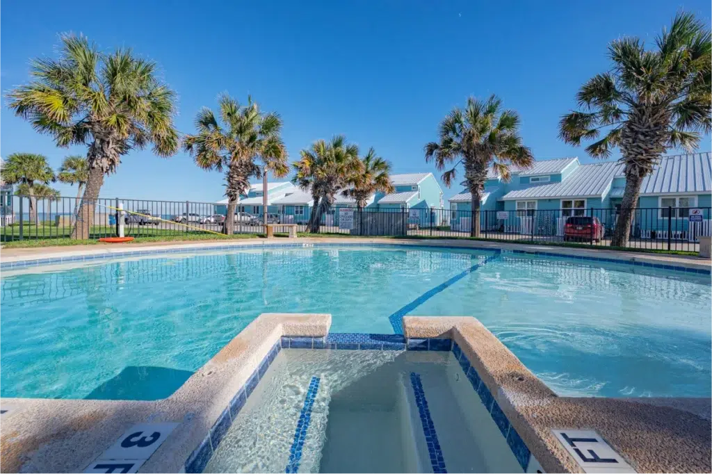 Outdoor pool with palm trees and cottages