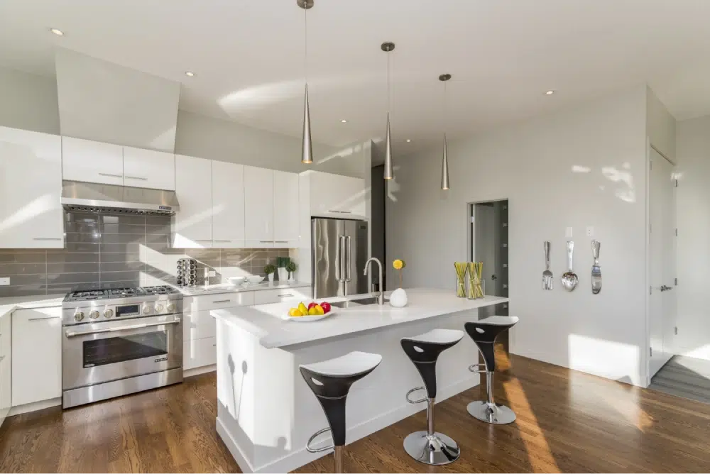 Modern kitchen with white cabinets, a central island, and stainless steel appliances.